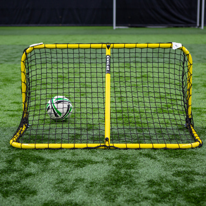 A soccer ball rests in a small netted futsal goal on green turf, demonstrating the convenience of the Replacement Support Arm For Keeper Goals Folding Aluminum Soccer Goal for fast setup and portability.